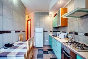 キーウにあるApartments near Khreshchatyk-Absolutのキッチン(青いキャビネット、白い冷蔵庫付)