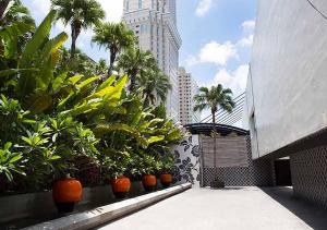 a courtyard with plants and palm trees and a tall building at Royal Group Motel Ming Zu Branch in Kaohsiung