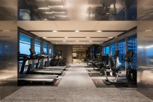 un gimnasio con una fila de pisadas y máquinas en HUAN Serviced Residence en Taichung