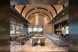 a restaurant with wooden tables and chairs and a large ceiling at HUAN Serviced Residence in Taichung