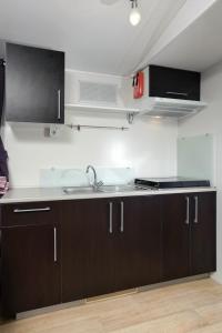 a kitchen with a sink, stove, microwave and cabinets at Solaris Camping Mobile Homes in Šibenik