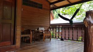 a wooden porch with a table and chairs on a deck at Longtail Beach Resort in Thong Nai Pan Yai