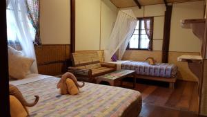 a bedroom with a stuffed animal sitting on a bed at Longtail Beach Resort in Thong Nai Pan Yai