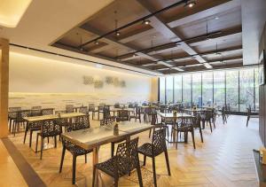 een restaurant met tafels en stoelen en een groot raam bij Royal Group Hotel Minghua Branch in Kaohsiung