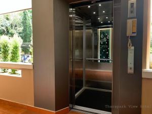 a glass shower in a room with a window at Tharapark View Hotel - SHA Plus in Krabi town