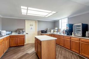 a large kitchen with wooden cabinets and a skylight at Clarion Inn Willow River in Sevierville