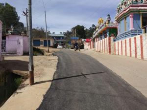 an empty street in a town with a person on a motorcycle at Pears Tree Duplex Villa in Kodaikānāl