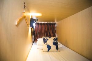 a small room with a bed and a window at Traveller Bunker Hostel in Cameron Highlands