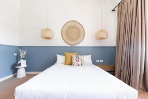 a bed room with a white bedspread and a white dresser at Lorne Hotel in Lorne