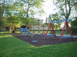 un parc avec une aire de jeux avec des balançoires dans l'établissement Torre de Quintana, à Suances