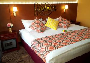 فندق نيو ويست في أولان باتور: غرفة فندق مع سرير كبير مع وسائد ملونة
