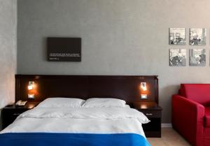 1 dormitorio con 1 cama grande y 1 silla roja en Residence Annunziata, en Messina