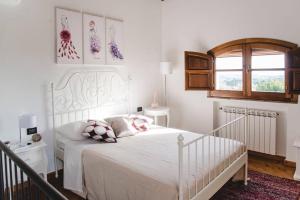 ein weißes Schlafzimmer mit einem Bett und einem Fenster in der Unterkunft Il Fienile di Tigliano in Vinci
