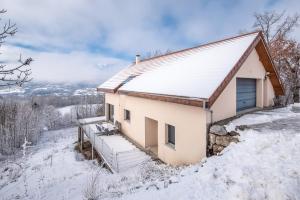 una casa en la cima de una colina nevada en Appart'hôtel "Le Garage" en Saint-Bonnet-en-Champsaur