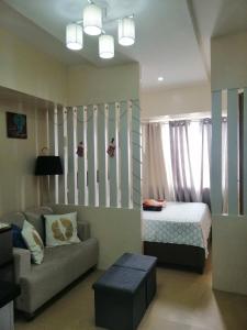 a living room with a bed and a couch at Cozy Studio Unit at Davao City Downtown Area in Davao City