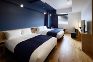 a hotel room with a bed and a desk at the square hotel KANAZAWA in Kanazawa