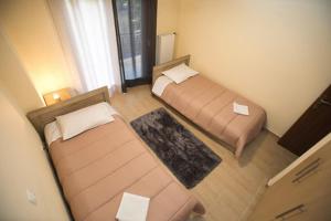 a small room with two beds and a window at Athenian Riviera Apartment in Athens