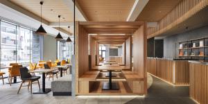 un ristorante con pavimenti e tavoli in legno e sedie di the square hotel KANAZAWA a Kanazawa