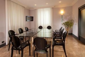 einen Konferenzraum mit einem Glastisch und Stühlen in der Unterkunft Hotel Buenos Aires in Rom