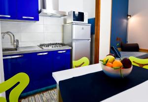 a kitchen with a bowl of fruit on a table at Residence Orchidea in Pietra Ligure