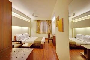a hotel room with two beds and a table at Whispering Palms Hotel Jaipur in Jaipur