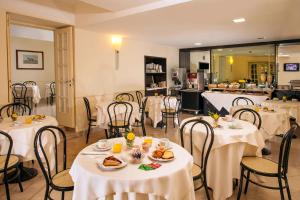 ローマにあるHotel Buenos Airesのテーブルと椅子が並ぶレストラン