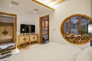 a bedroom with a bed and a tv and a mirror at Su Xin Resort Inn in Zhangjiajie