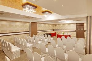 a conference room with white chairs and a table at Whispering Palms Hotel Jaipur in Jaipur