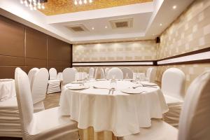 a conference room with a white table and white chairs at Whispering Palms Hotel Jaipur in Jaipur