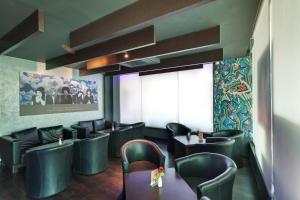 a restaurant with black leather chairs and tables and a window at Whispering Palms Hotel Jaipur in Jaipur