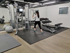 a woman is in a gym performing squats at Modern Times Hotel Vevey in Vevey
