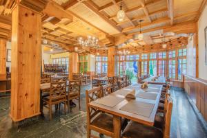 une salle à manger avec des tables et des chaises en bois dans l'établissement Hotel The Kaal, à Leh