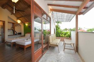 a room with a bedroom with a bed and a balcony at An Bang Beach Villa in Hoi An