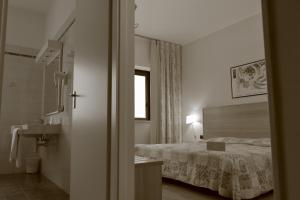 a hotel room with a bed and a mirror at Hotel Romanisio in Fossano
