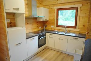 a kitchen with white cabinets and a sink and a window at Héron d'Argent in Meurimont +5 photos