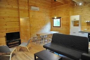 Cette chambre dispose de murs en bois et d'une cuisine avec des tables et des chaises. dans l'établissement Héron d'Argent, à Meurimont
