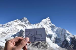 a person holding a card in front of a mountain at Shanghai Hidden Garden International Youth Hostel in Shanghai
