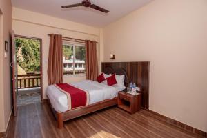 um quarto com uma cama e uma janela em The Country Yard em Pokhara