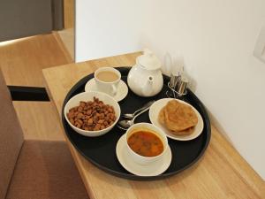 um tabuleiro preto com tigelas de comida numa mesa em The Country Yard em Pokhara