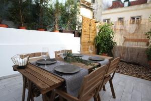 Casa Glória في لشبونة: طاولة خشبية مع لوحات واكواب على الفناء