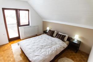 - une chambre avec un lit blanc et une fenêtre dans l'établissement D&J house, à Ormoz