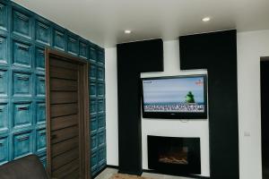 a room with a tv on a wall with a fireplace at Luxury Apartment in Sumy