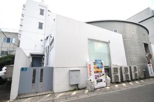 - un bâtiment blanc avec un réfrigérateur en face dans l'établissement Guest room Kamakura Nagomi -Camellia-, à Kamakura