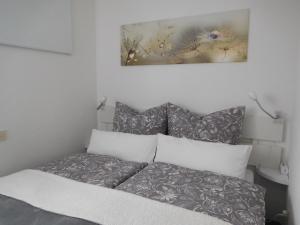 1 cama en un dormitorio con una foto en la pared en Ferienwohnung Schwarzwaldrauschen, en Schönwald