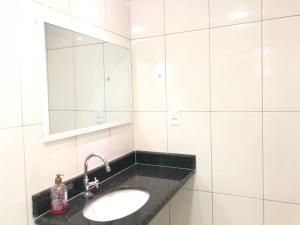 une salle de bain avec un lavabo et un miroir dans l'établissement Temporada Arraial do Cabo, à Arraial do Cabo 11 autres photos