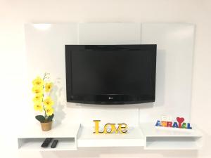 Elle comprend une télévision à écran plat installée sur un mur blanc. dans l'établissement Temporada Arraial do Cabo, à Arraial do Cabo