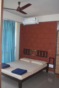 a bed in a room with a ceiling fan at Oasis Resort in Diveagar
