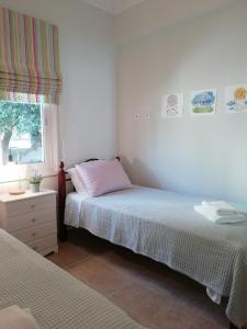 a bedroom with two beds and a window at Dimitris' & Valentina's Home in Plakias