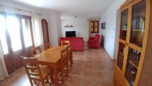 卡拉馬奎達的住宿－Cala Mesquida，一间带桌子和红色椅子的用餐室