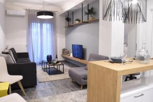 ein Wohnzimmer mit einem Sofa und einem TV in der Unterkunft Alpinia n Lotus Apts. (Must) in Thessaloniki